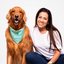 Foto de Gabriella, uma mulher branca de cabelos castanhos e longos com camiseta e jeans, e Zoff, um golden retriever usando uma bandana verde