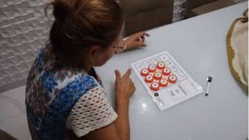 Aluna brincando com jogo de tabuleiro "Gondol" - Foto: arquivo pessoal