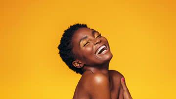 Mulher de olhos fechados ri