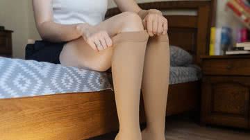 Mulher colocando meia calça