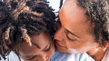 Mãe fala amorosamente perto do ouvido de criança