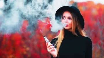 Garota adolescente fuma cigarro eletrônico.