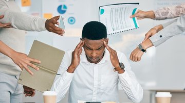 Homem em ambiente de trabalho com várias mãos à volta