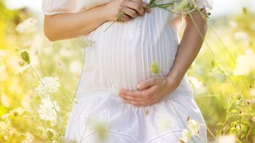 Mulher grávida segura sua barriga