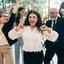 Homens e mulheres adultos em roupas de trabalho e ambiente corporativo comemoram juntos