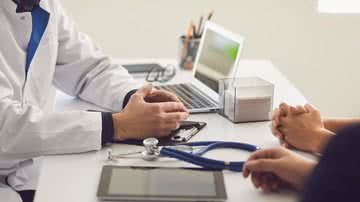imagem de uma mesa durante atendimento de pacientes por um médico