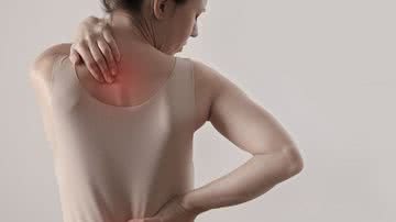 Mulher de costas massageando costas com dor