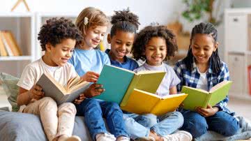 Cinco crianças leem livros juntas