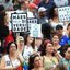 Mulheres segundando placas que dizem " Mães pela diversidade" caminham em passeata